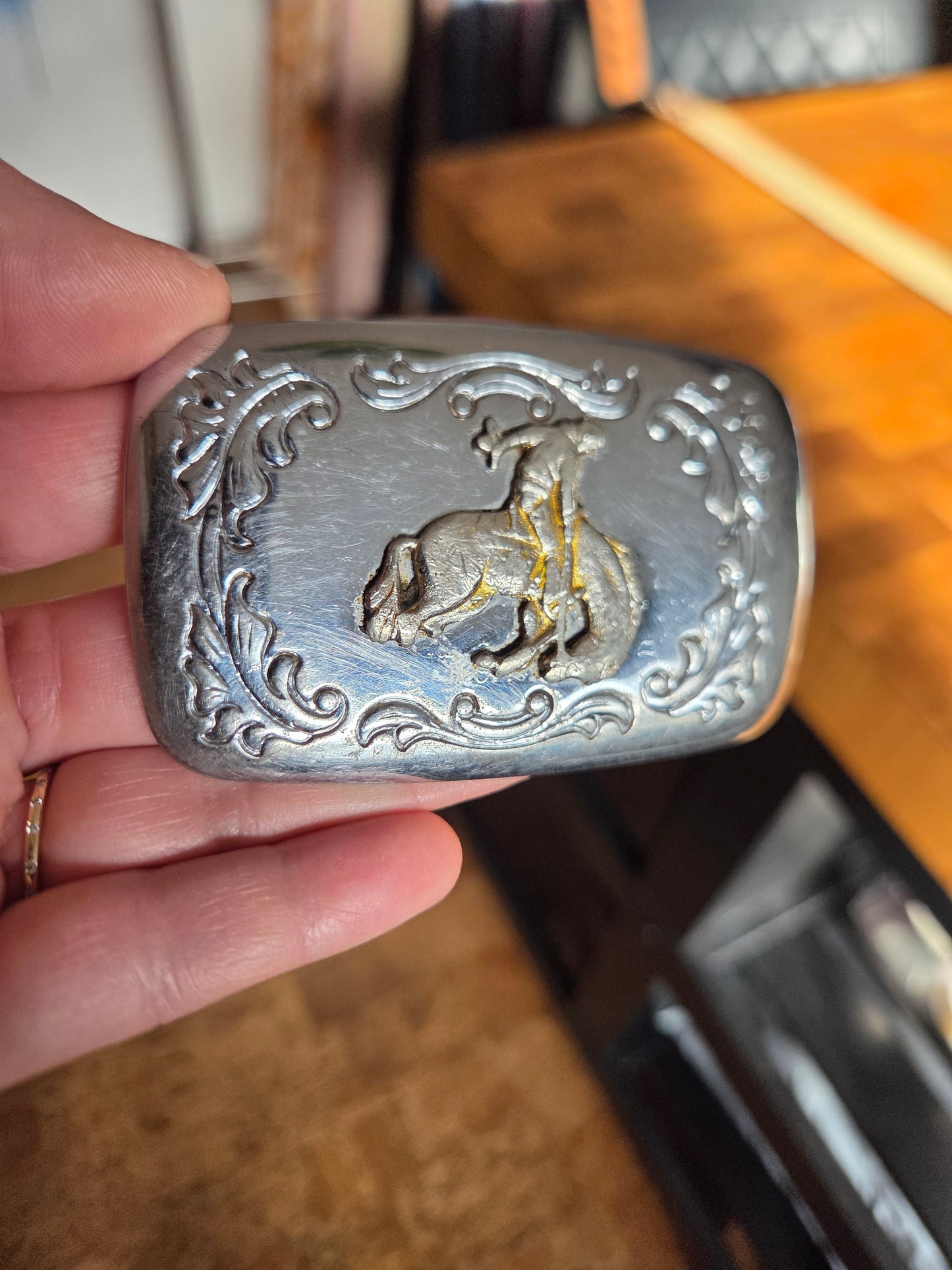 Metal belt buckle with bucking bronco cowboy and tan belt