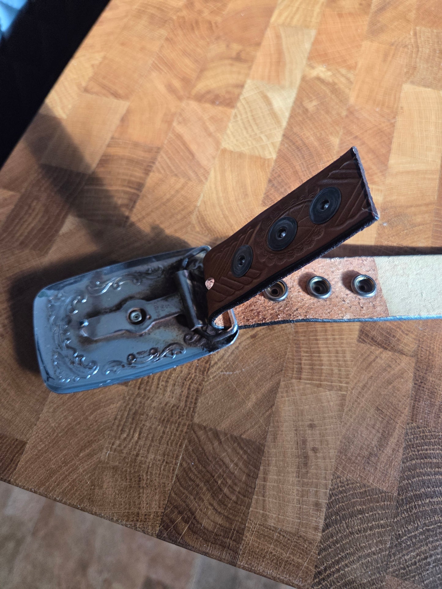 Metal belt buckle with bucking bronco cowboy and tan belt