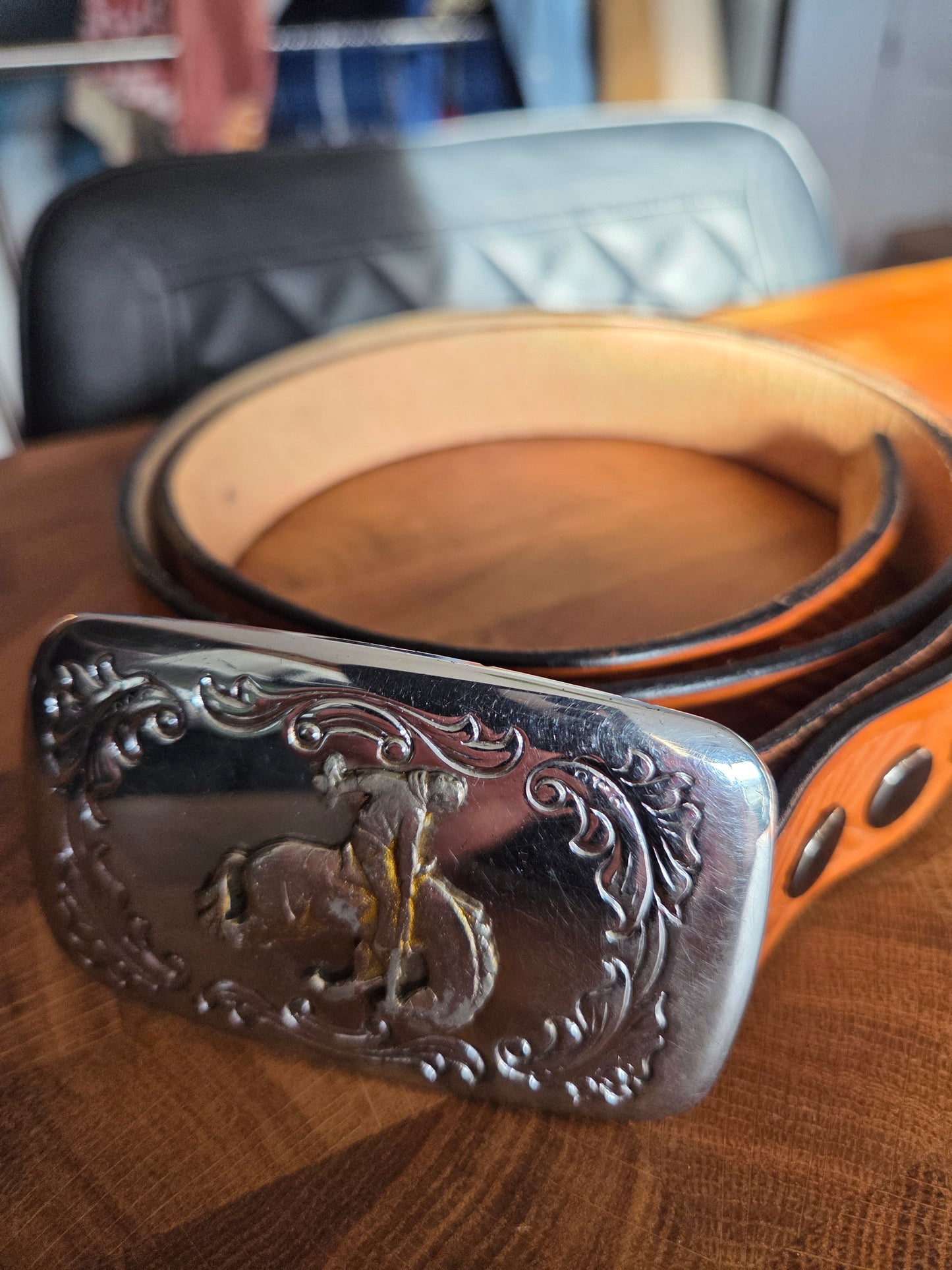 Metal belt buckle with bucking bronco cowboy and tan belt