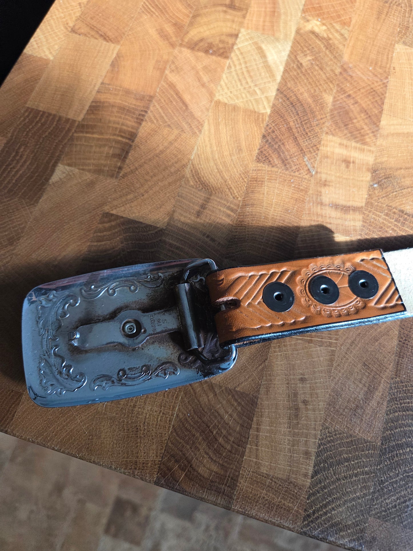 Metal belt buckle with bucking bronco cowboy and tan belt